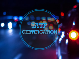 IATF Certification Logo in blau mit Industrie Hintergrund