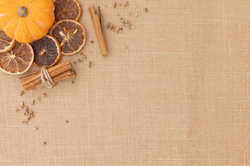 Munchkin pumpkin, orange slices, cinnamon, coriander seeds displayed on hessian shot from above with copysapce
