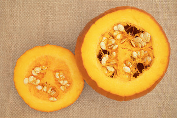 Focus stacked image of a pumpkin with top cut off, displayed on hessian background shot from above