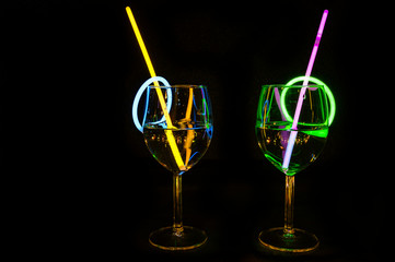 Holiday party delicious drink in a bar wine glass colorful light reflection with dark background for holidays, christmas, new year and gathering