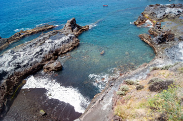 Spain – Tenerife island :  Atlantic waves create surf at an indented small bay on the south coast. The sea and cliffs create a simple and powerful view of the force of nature.