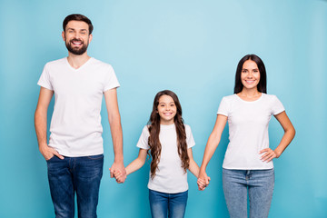 Portrait of cheerful content three people with wavy curly hair hold hand enjoy family weekends day wear white t-shirt denim jeans isolated over blue color background