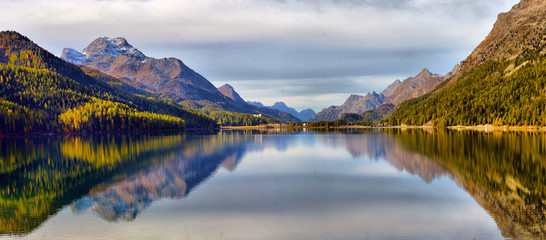 Mountain lake panorama with mountains reflection. Idyllic look. Autumn forest. Silvaplana Lake,...