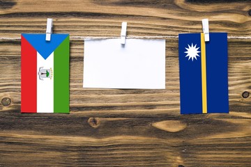Hanging flags of Equatorial Guinea and Nauru attached to rope with clothes pins with copy space on...