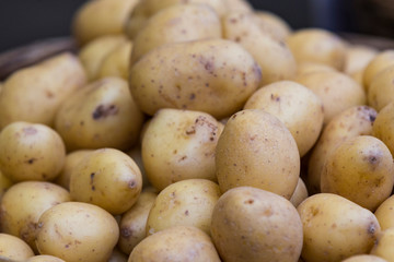 Raw potatoes in baskets on the market close up shot