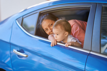 Two young sisters looking from car window