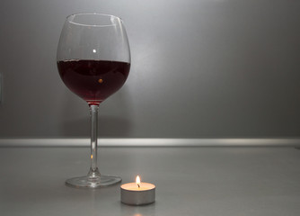 glass of red wine and candle