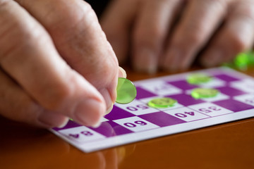 Fototapeta na wymiar Close Up Of Senior Man Playing Game Of Bingo