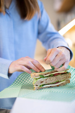 Close Up Of Woman Wrapping Sandwich In Reusable Environmentally Friendly Beeswax Wrap