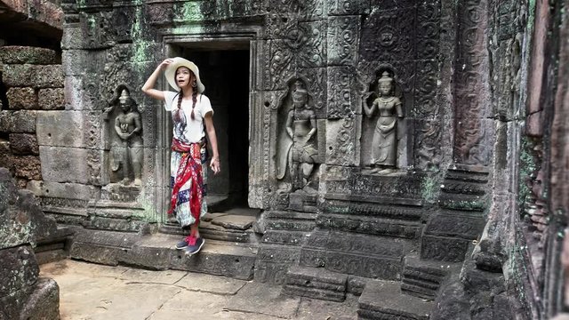 4K, Beautiful asian woman take a walk in ancient Hindu temple of Ta Som. Tourist girl walks alone through the walls of archaeological temples in Siam Reap, historic area of Angkor Thom. Cambodia-Dan