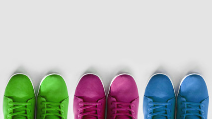 group of multi-colored sneakers on a white background. Concept - a problem with the choice of shoe colors in the modern industry, copyspace, flatlay