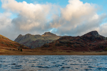 Morning light at Blea Tarn in the English Lake District with views of the Langdale Pikes, and Side Pike during autumn.