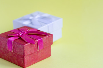 pink and white gift boxes on light yellow background, time to buy gifts