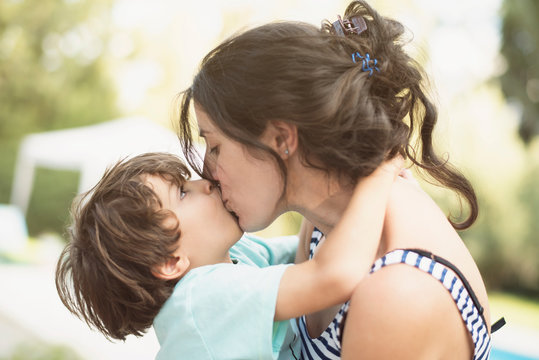 mother and son kiss in summer day