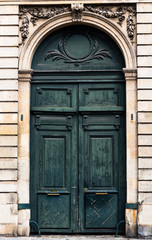 Old worn and weathered green vintage wooden Door in Paris, France