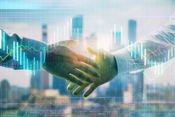 Obraz na płótnie Canvas Double exposure of financial graph on cityscape background with two businessman handshake. Concept of stock market deal