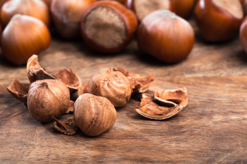 close up of hazelnuts on wooden table .