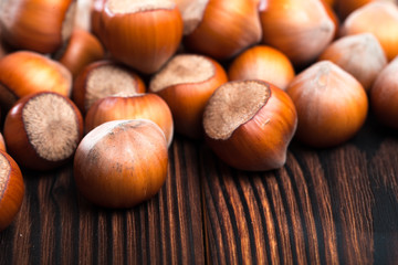 close up of hazelnuts on wooden table .