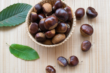sweet chestnuts in a basket on a wooden table