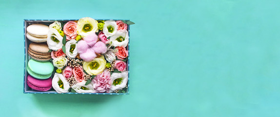 Obraz na płótnie Canvas Mint box of tender flowers and bright macarons. Romantic gift. Mint banner with copy space for text.