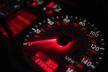 car dashboard. Speedometer with red backlight at night close up