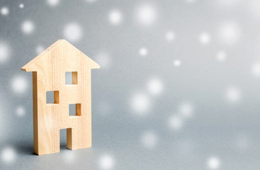 Miniature wooden house and snowflakes. Demand for real estate in the winter. Christmas discounts and sale. Rental of housing. Buying houses and apartments. Favorable prices