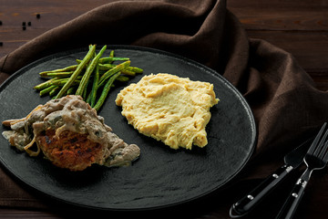 Meat Burger with Mushroom Gravy, Smashed Potatoes and Green Beans on Wooden Table.