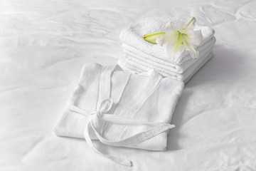 Soft clean bathrobe and towels on bed - obrazy, fototapety, plakaty