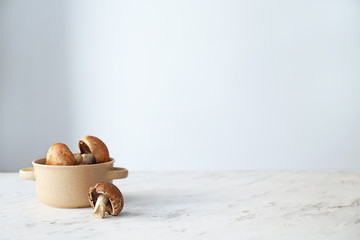 Fresh champignon mushroom in pot on table