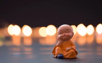 Fotobehang Boeddha Monk baby is leaning his head on his hand, Far East temple culture  © daphnusia