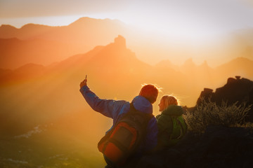 father with little daughter making selfie in mountains, family travel