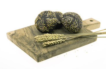 black round bread sprinkled with sesame on a cutting board, white background