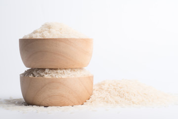 Clean rice grain in a brown wooden bowl on a white background.