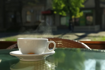 Cup of fresh aromatic coffee at table in cafe