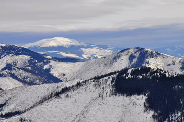 Obraz premium Winter landscape of Low Tatras mountains situated in the heart of Slovakia. Forests destroyed by human activity. Carpathian mountains. Kráľova hoľa peak. 
