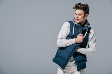 fashionable man posing in autumn waistcoat, isolated on grey