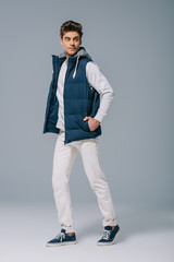 fashionable male model posing in autumn waistcoat on grey