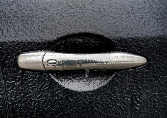  Black car coated ice crust during the  icy rain in cold weather. Handle door opening and windows...