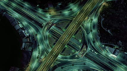 Aerial view of Smart transportation with Expressway, Road and Roundabout, busy highway traffic night time. Important infrastructure.