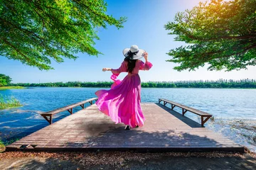 Rolgordijnen Young tourist stands on Nong Han Pier. Near the lotus garden in Sakon Nakhon Province,Thailand. © chanchai