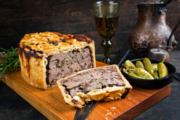 Traditionelle französische Pate en croute mit Gänseleber und Fleisch als closeup mit Gurke und...