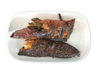 Grilled fish served on plate, dried crust skin, well-done level, isolated on white background, top view. Asian cuisine style.