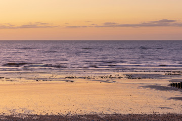 Early morning sunrise with orange sky and beach , purple sea