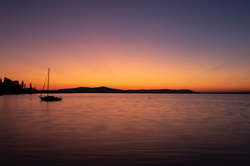 Naklejka na ściany i meble Sunrise at a lake with boat in the foreground