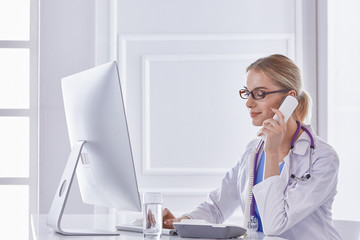 Portrait of a happy smiling young doctor in headset in office