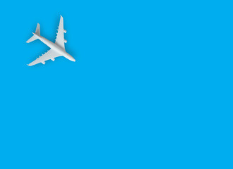 Miniature toy airplane white on blue background.