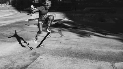 Foto op Plexiglas Jong meisje dat trucs uitvoert met het skateboard in een skatepark © oneinchpunch