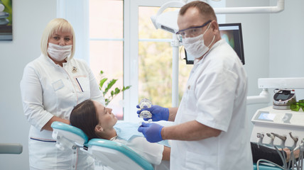 Doctor dentist treats teeth of a beautiful young girl patient. The girl on reception at the dentist. Doctor dentist treats tooth