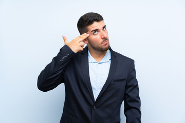 Handsome man over isolated blue background with problems making suicide gesture