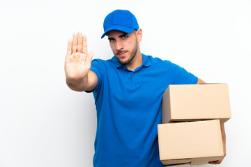 Fototapeta na wymiar Delivery man over isolated white background making stop gesture with her hand